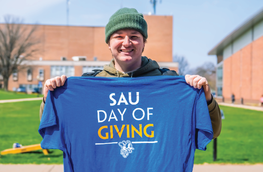 SAU Student holding a Day of Giving shirt