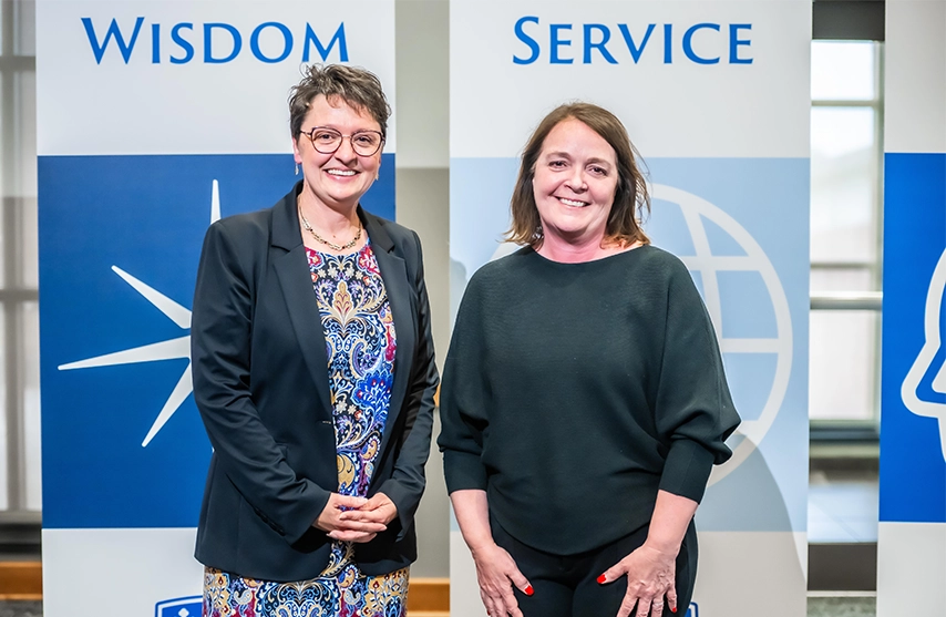 Amy Novak, EdD stands alongside Anne Lansing ’88, ’15 MOL, OTD and smiles at the camera.