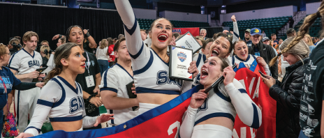 Cheerleaders celebrate with national championship trophy.