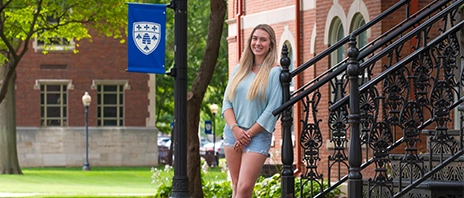 Irene Artabe smiles at the camera while leaning on a metal railing.