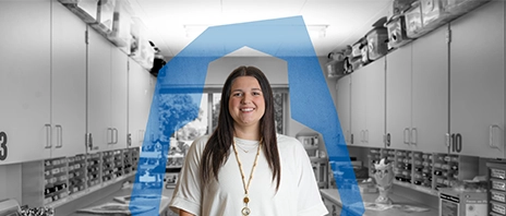 Lauren Posten, '24, '26 MSLP, stands in a lab at St. Ambrose University and smiles into the camera. A blue 