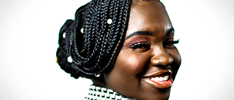 Lydia Amissa-Harris smiles over one shoulder at the camera against a white background.
