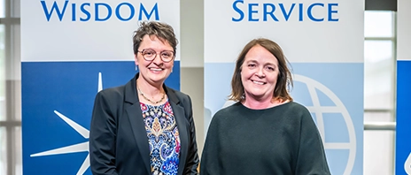 Amy Novak, EdD stands alongside Anne Lansing ’88, ’15 MOL, OTD and smiles at the camera.