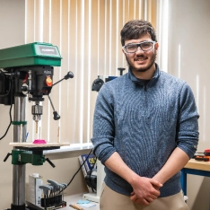 Engineering student smiling in lab.