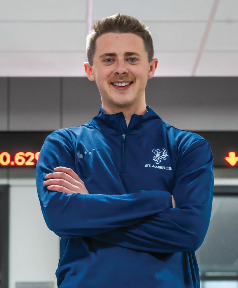 Student standing in business school hallway.