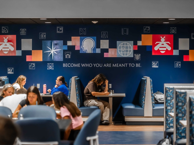 A crowded dining hall, one student sits beneath the words 