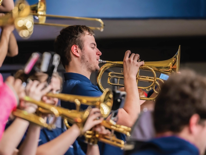 Member of pep band playing indoors.