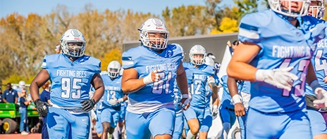 SAU football players rush onto the field to begin their match.