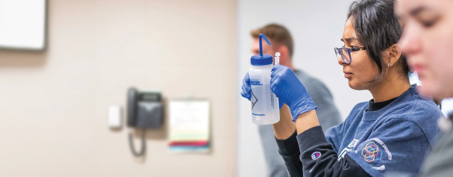 Biology student studying sample in biology lab.