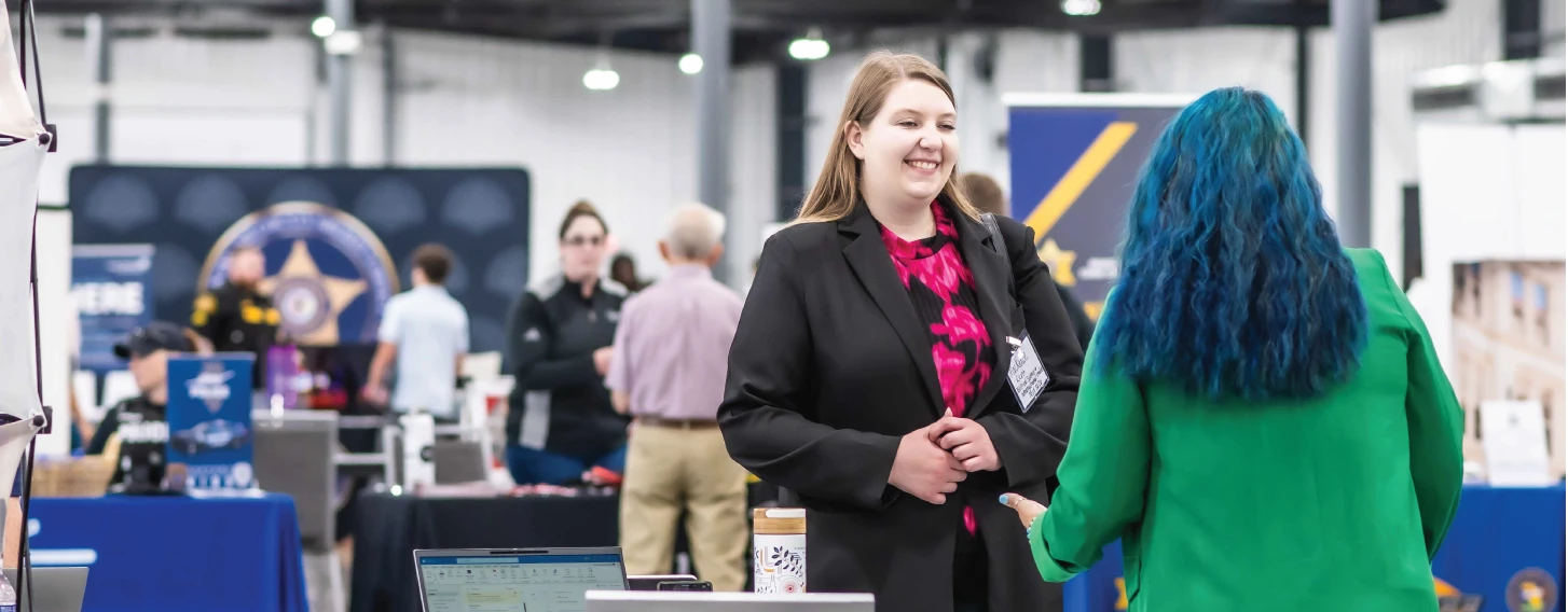 Student speaking with employer at career fair.