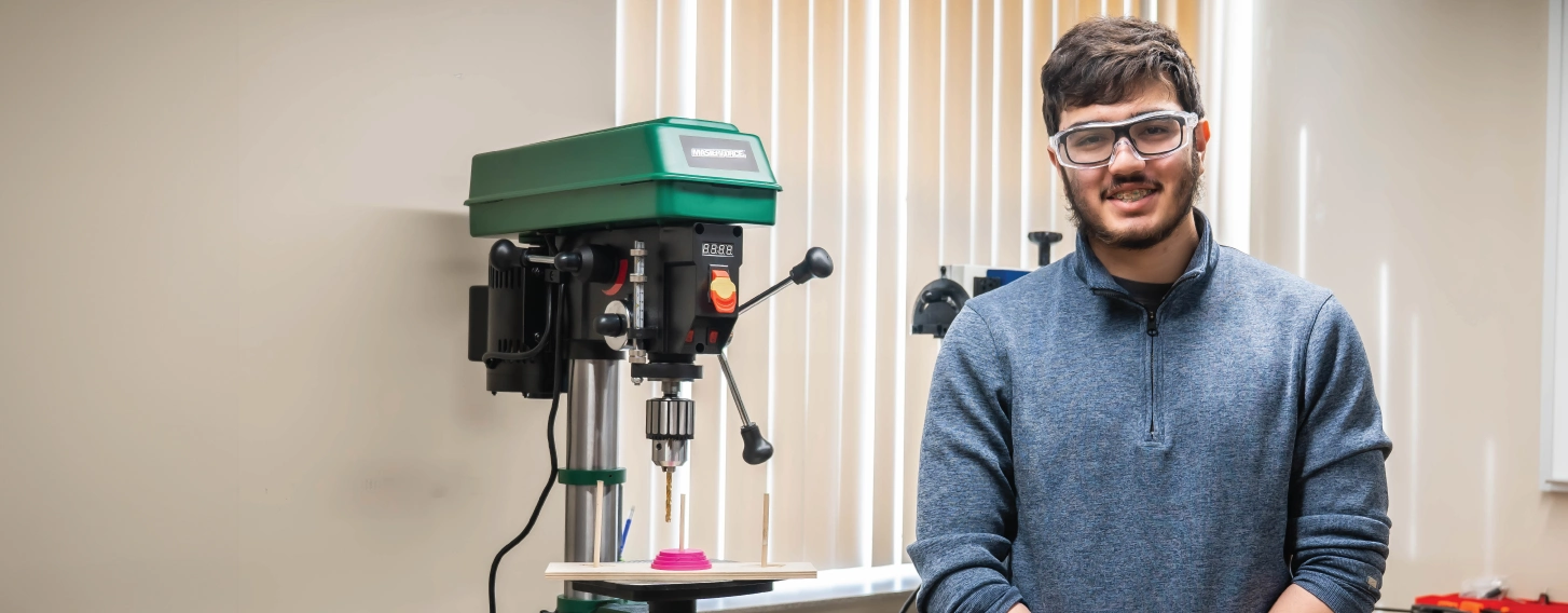 Engineering student smiling in lab.