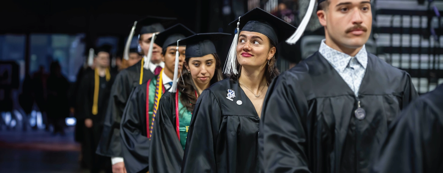 Graduate walking in a line during commencement.