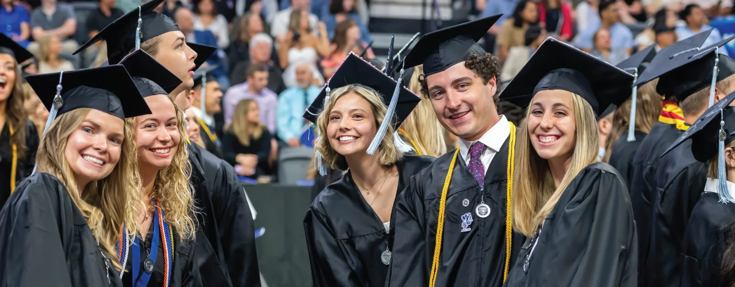 Group of graduates smiling before ceremony.