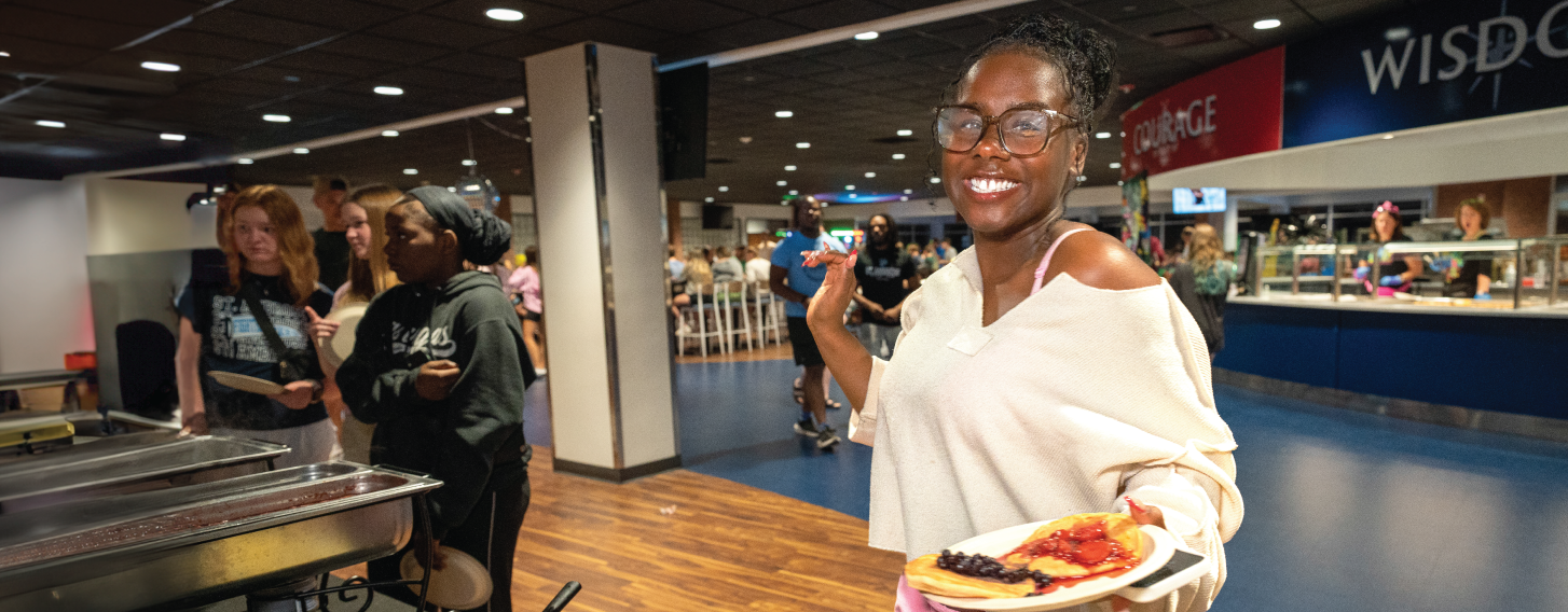 Student in Grove dining hall, smiling.