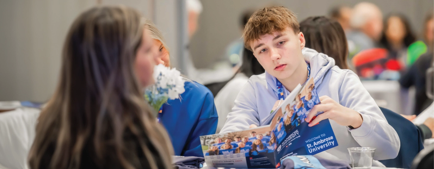 Student studies St. Ambrose brochure