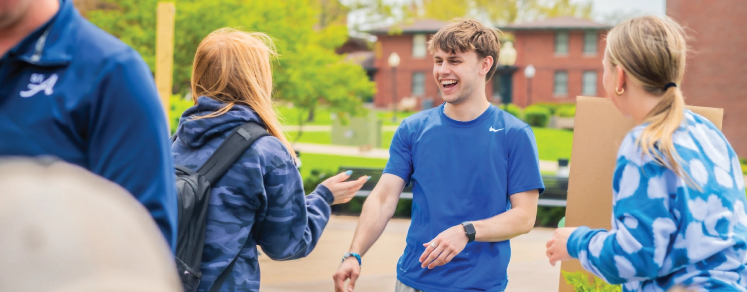 Student outdoors, smiling.